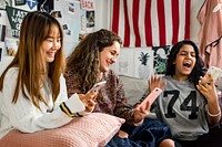 Teenage girls using smartphones in a bedroom internet in slumber party