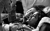 Teenage girls lying on the bed together holding stuffed animal childhood and friendship concept