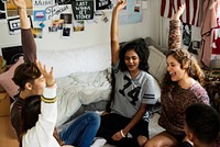 Group of teenagers in a bedroom arms raised community and temwork concept