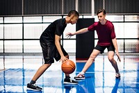 Two teenage boys playing basketball together on the court