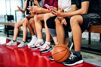 Group of young teenager friends on a basketball court relaxing using smartphone addiction concept