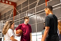 Group of teenager friends on a basketball court talking<br />