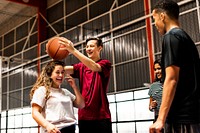 Playful group of teenager friends on a basketball court