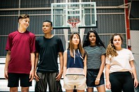 Group of young teenager friends on a basketball court standing in a row