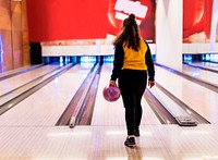 Girl about to roll a bowling ball hobby and leisure concept