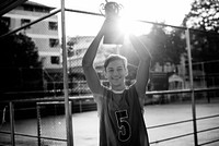 Caucasian teenage boy in sporty clothes holding up a trophy outdoors