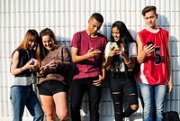 Group of young teenager friends chilling out together using smartphone social media concept