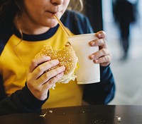 Close up of teenage girl eating hamburger obesity concept