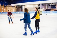 Teenage friends ice skating on the ice rink together
