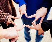 Group of friends using fingers to form the star shape teamwork and support concept