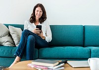 Woman using mobile phone on the sofa