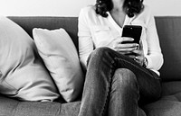 Woman using mobile phone on the sofa