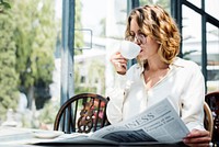 Business woman reading newspaper in the morning