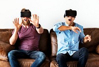 Men enjoying VR goggles on a couch