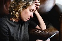 Depressed woman using a mobile phone