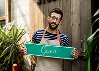 A person holding an "open" sign