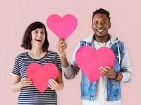 Happy couple holding pink heart icons