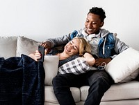 Interracial couple on a couch listening to music