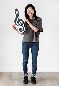 Asian ethnicity woman holding a musical note icon