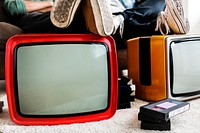 Two man sitting and two retro television