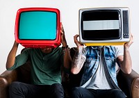 People holding retro television next to each other