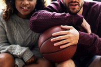 Young couple watching basketball match at home