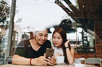 Couple using a phone at a cafe