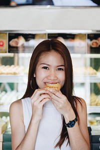 Asian girl having a bite of tart