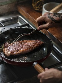 A chef cooking steak in a pan food photography recipe idea