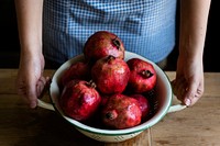 Fresh pomegranate in a bowl on a wooden table