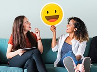 Woman holding emoticons on a couch