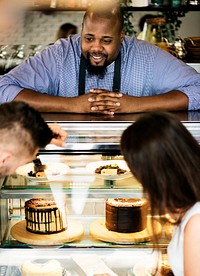 Customers choosing cake at the display fridge