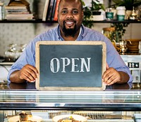A cheerful small business owner with open sign