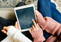 Women using digital tablet together