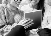Women using digital tablet together