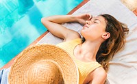 Young woman tanning poolside