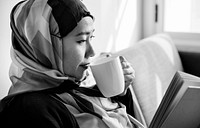 Islamic woman reading and drinking coffee