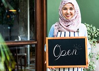 Islamic woman small business owner holding blackboard with smiling