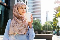 Muslim woman drinking coffee in the city