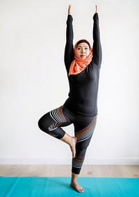 Muslim woman doing yoga in the room