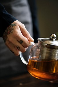 Tattooed woman holding a teapot