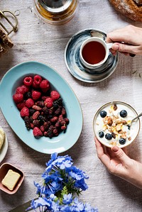 Woman enjoying berries and yogurt for breakfast