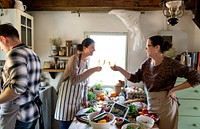 Happy friends cooking together in the kitchen