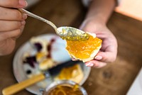 Spoonful of citrus jam on a piece of scone