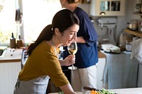 Women having white wine while cooking in a kitchen