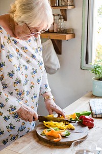 Grandmother cutting bell pepper on a cutting board