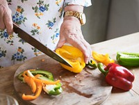 Elderly woman slicing bell peppers