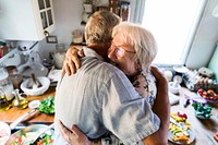 Cheerful senior people hugging in the kitchen