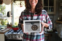 Happy woman holding a screen with a baking recipe