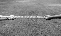 Closeup of hand pulling the rope in tug of war game